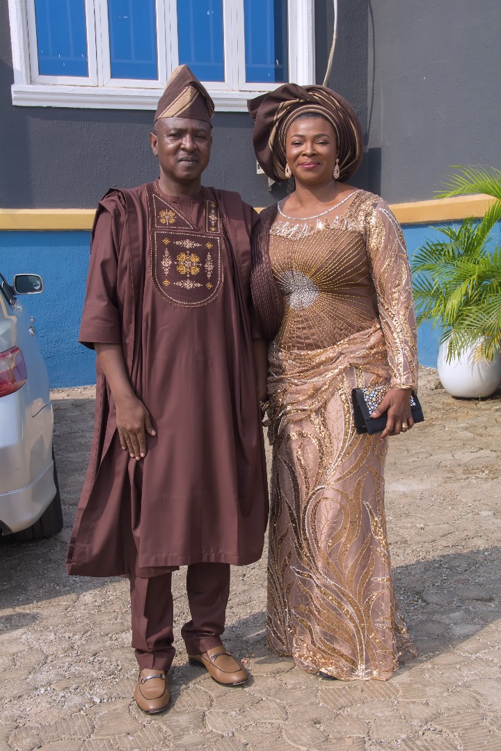 Couple in matching brown and gold aso-ebi