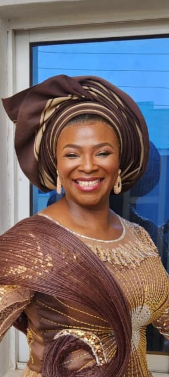 Abigail Pwajok wearing an elegant brown and gold gele